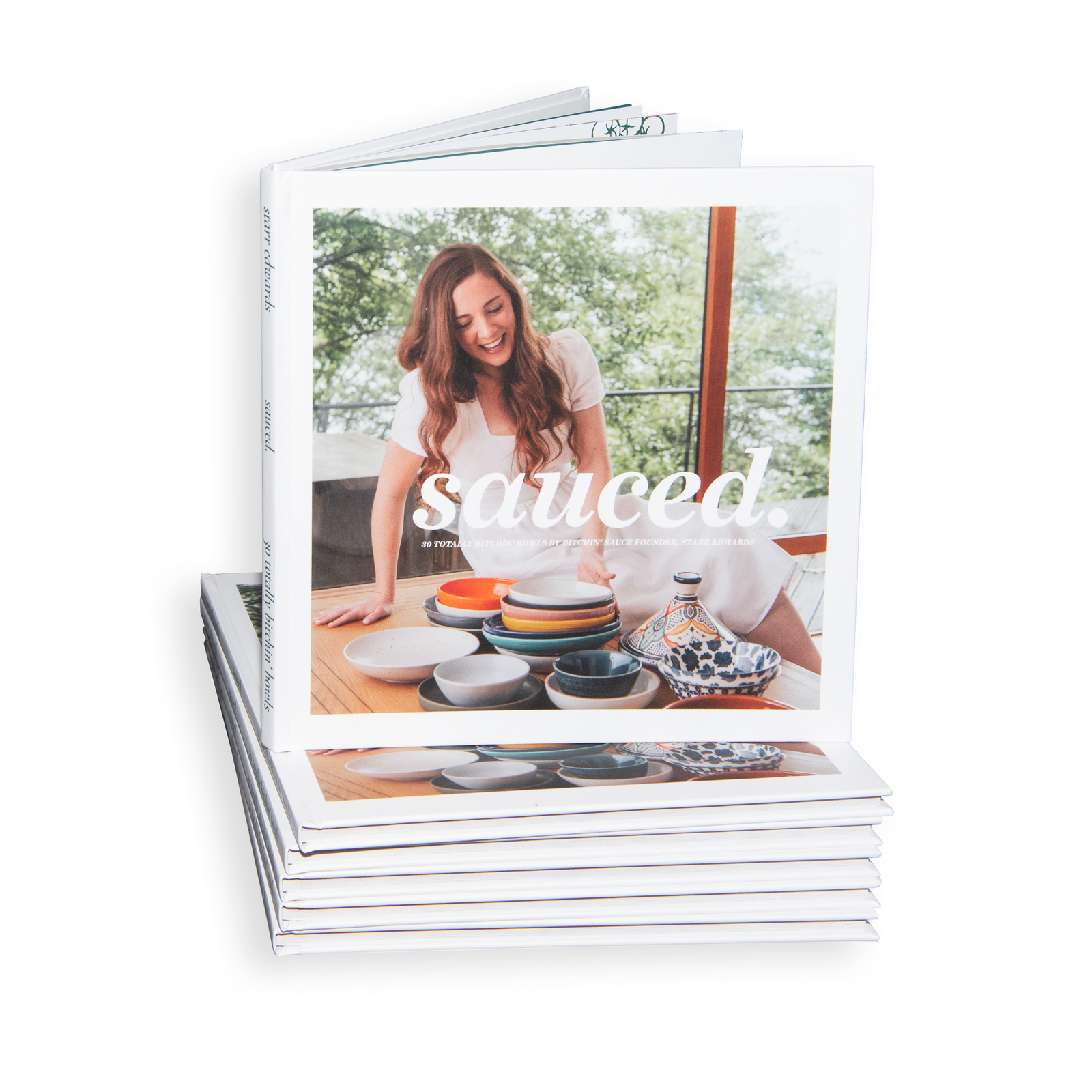 Stack of Sauced. 30 Totally Bitchin' Bowls cookbooks by Starr Edwards, showing the book cover with the author arranging bowls at a table.